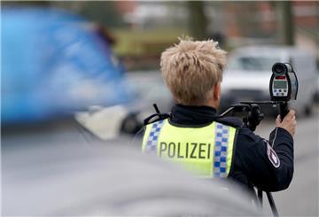 Eine Polizistin nimmt eine Geschwindigkeitsmessung in einer 30-Zone mit einem Laser an einer Straße vor.