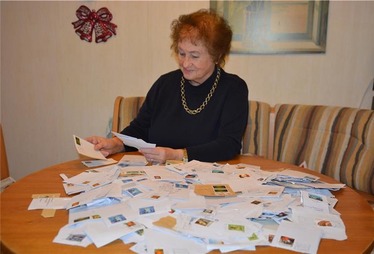 Stotelerin sammelt Briefmarken für Bethel Eine Frau sortiert Briefmarken auf einem Tisch.