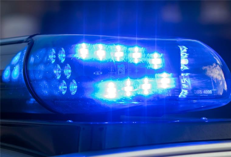 Das Blaulicht auf einem Fahrzeug der Polizei leuchtet in der Dunkelheit. 