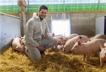 Jan-Peter Mehring mit einem Schutzanzug in einem Schweinestall.