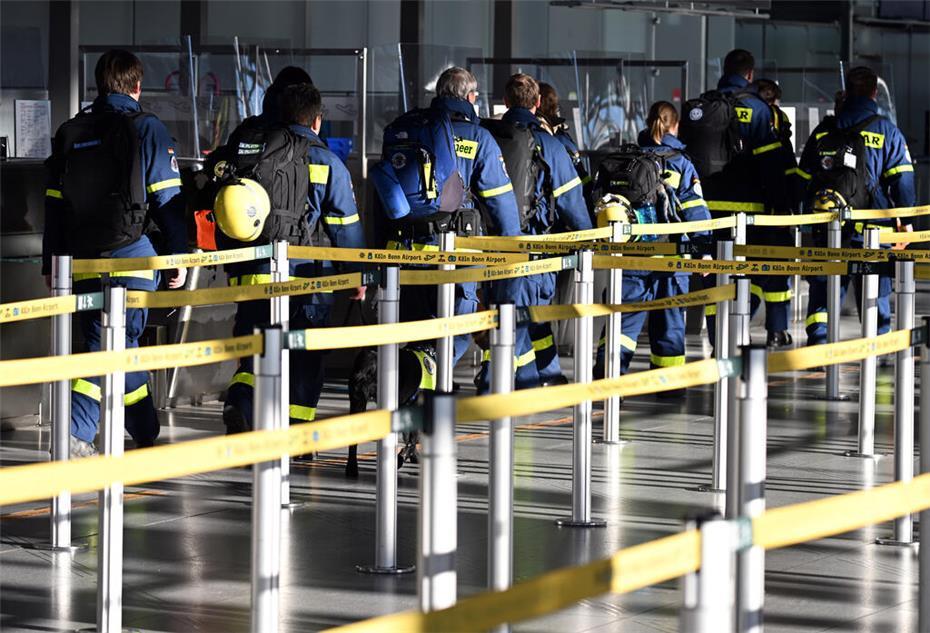 Köln: Rettungskräfte des Technischen Hilfswerks (THW) gehen durch den Flughafen Köln/Bonn.
