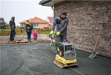 Bauarbeiter richtet eine Fläche mit einem Arbeitsgerät.