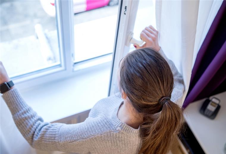 Frau öffnet Fenster