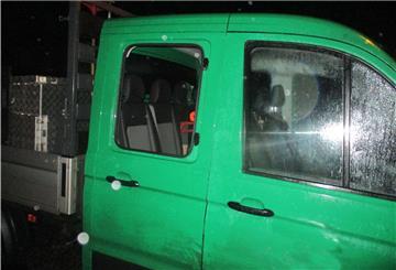 Ein grüner Pritschenwagen mit eingeschlagenem Fenster.