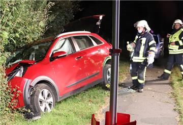 Rotes Auto im Graben, Feuerwehrleute