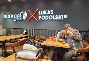 Ein Mann isst einen Döner Kebab in einem Laden von Ex-Fußballstar Lukas Podolski.