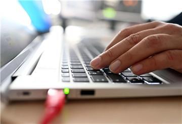 Eine Hand tippt auf der Tastatur eines Laptops.