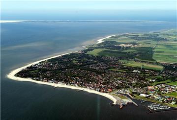 Die Luftaufnahme zeigt die Insel Föhr vor der Nordseeküste von Schleswig-Holstein. Urlaub auf Föhr muss nicht teuer sein: Mit Bollerwagen, Buchungslücke und Heubett lässt sich die Nordseeinsel günstig genießen.