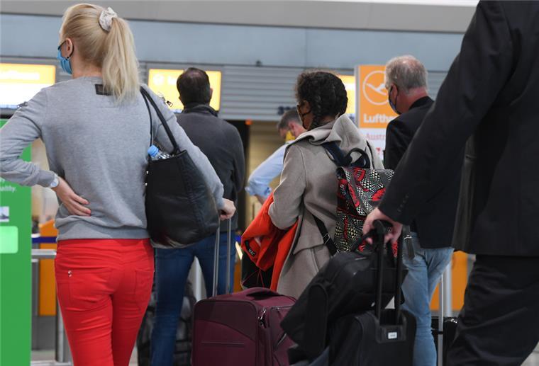 Gute Nachrichten für Urlaubsrückkehrer: Corona-Regeln werden gelockert Flugreisende warten in der Abflughalle Terminal 1 des Frankfurter Flughafens vor einem Check-in-Schalter.