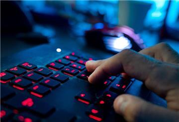 Ein Mann sitzt am Rechner und tippt auf einer Tastatur.