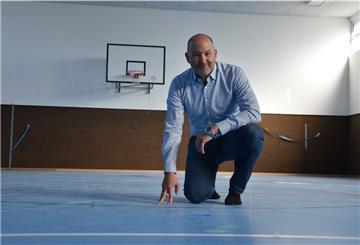Uthledes Ortsbürgermeister Marco Vehrenkamp (SPD) zeigt den neuen Boden in der Turnhalle.