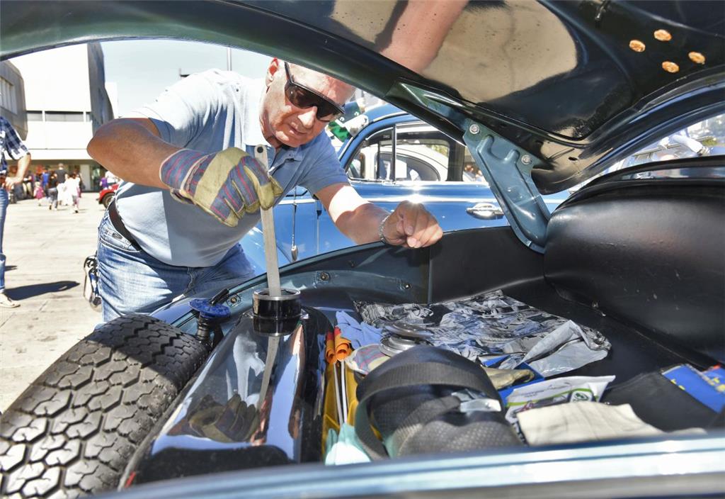 Uwe Scherer peilt den Kraftstoffstand seines 1958er VW-Käfer 1200. - Foto: Sches...