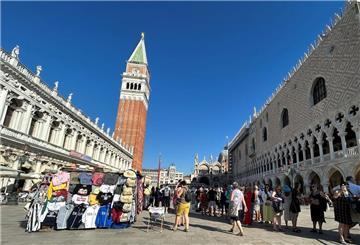 Touristen stehen auf dem Markusplatz in Venedig. 