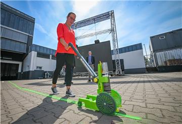 Veranstaltungsleiterin Jacqueline Stransky malt die Markierungen für die Autos auf den Boden vor der Stadthalle - normalerweise machen das die Techniker.