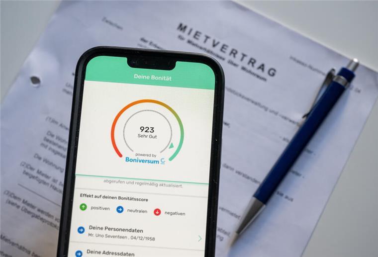 Verbraucherzentrale kritisiert Bonify-App der Schufa Ein Screenshot der App „Bonify“ ist auf dem Bildschirm eines Mobiltelefon vor einem Mietvertrag zu sehen.