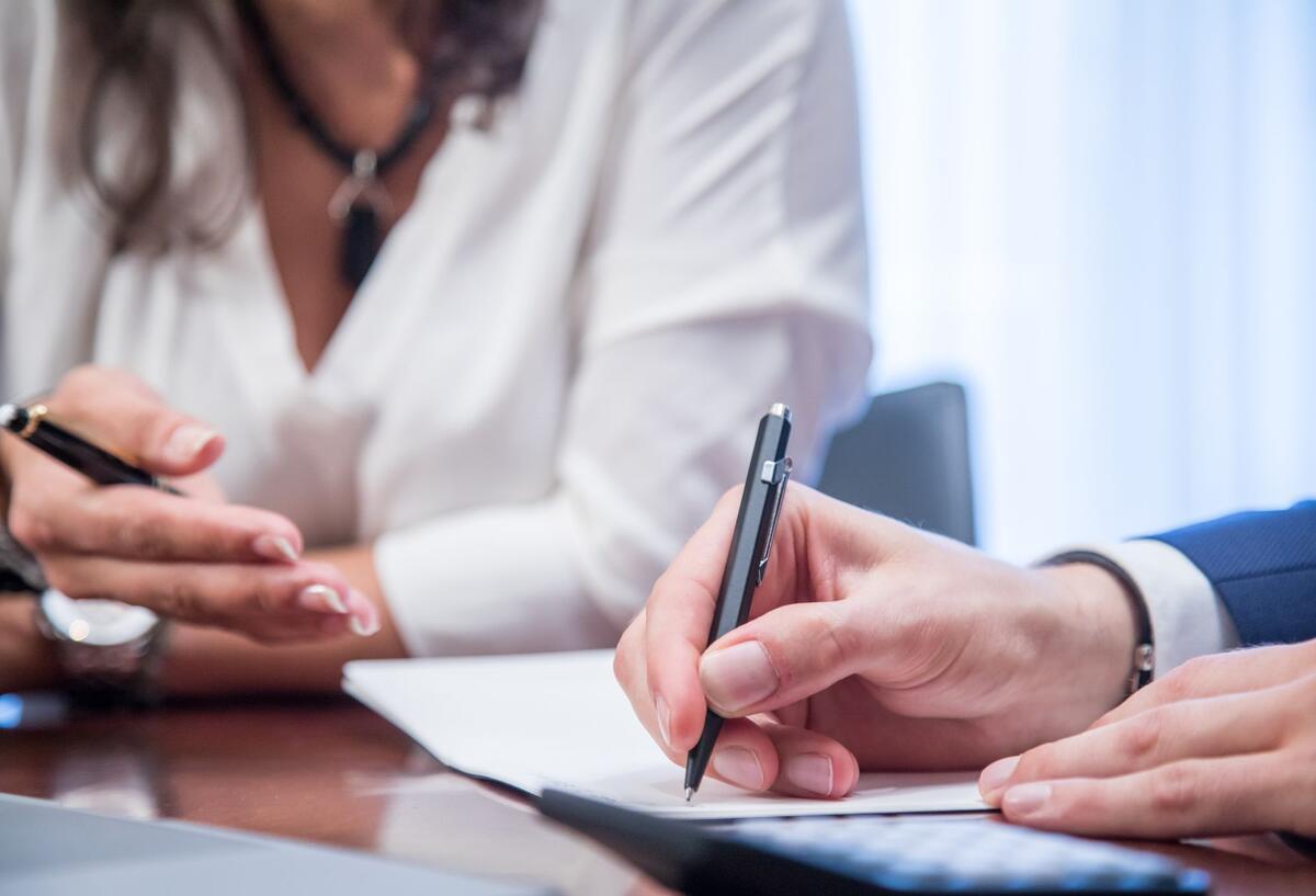 Verbraucherzentrale alarmiert! Vor dieser Versicherung warnen Experten 2 Menschen sind dabei, ein Dokument zu unterschreiben.