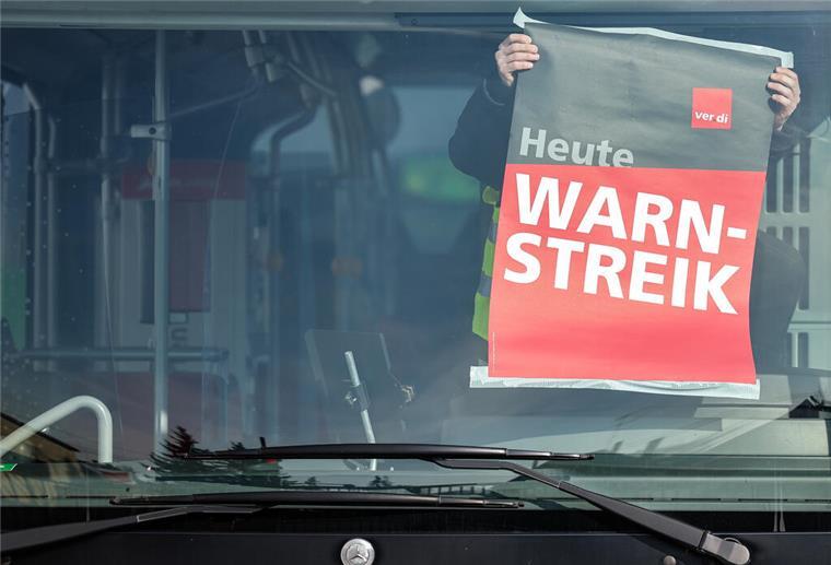 Ein Mann hängt ein Plakat in einem Bus auf, darauf steht: "Heute Warnstreik". Verdi ruft zu Warnstreiks auf: Beschäftigte der KVG Stade wollen am 14. Mai ab 10 Uhr am Betriebshof in Cuxhaven demonstrieren.
