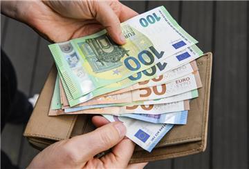 Eine Frau hält eine Geldbörse und mehrere Geldscheine in den Händen. Je nach Alter variiert das Einkommen. Wir zeigen, was die Deutschen im Durchschnitt verdienen. 