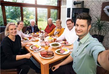 Mitglieder der Familie Mühlenbeck haben sich zum Grünkohl-Essen an einem Tisch versammelt.