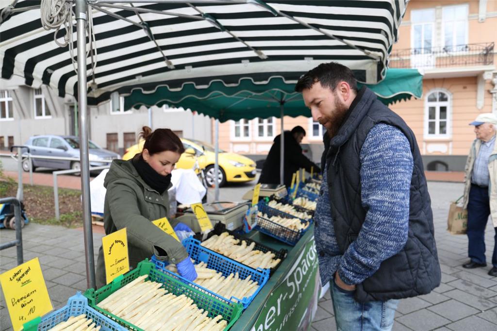 Verkauf auf dem Wochenmarkt: Kunde Marcel Freund im Gespräch mit Vicky Rusean vom Spargelhof Appel.