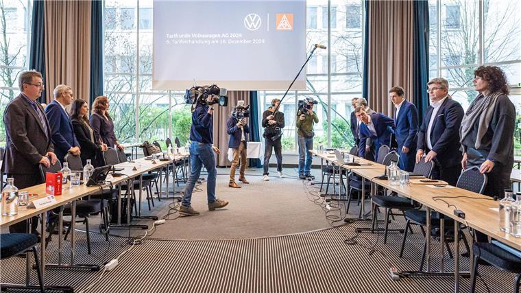 Vertreter von Volkswagen (r) und IG Metall (l) vor Beginn der fünften Tarifverhandlung in Hannover.