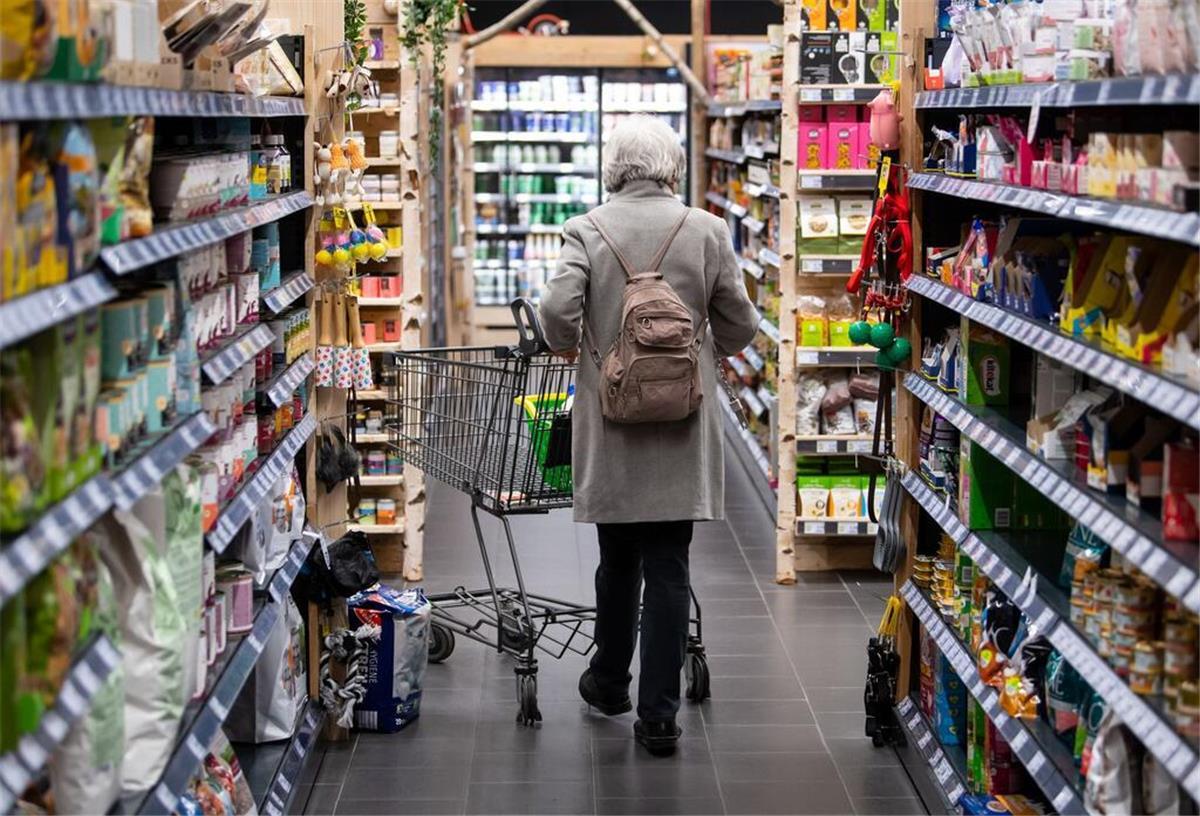 Eine Frau läuft durch einen Supermarkt.