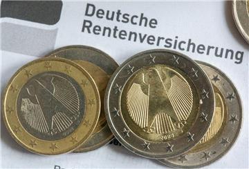 Geldmünzen liegen auf einem Schreiben der Deutschen Rentenversicherung, 