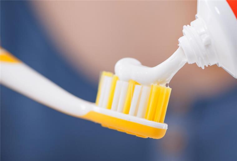 Zahnpasta auf einer Zahnbürste. Viele Kosmetika enthalten Chemikalien, die sich nur schwer abbauen lassen und so über Jahre in der Umwelt verbleiben – bewusster Konsum kann helfen, sie zu vermeiden.