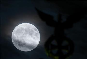 Ein besonders groß erscheinender Vollmond, auch Supermond genannt, ist bei leichter Bewölkung neben der Spitze der Quadriga auf dem Brandenburger Tor zu sehen. (zu dpa: «Neun Optionen: Nasa legt potenzielle Mond-Landestellen fest»)