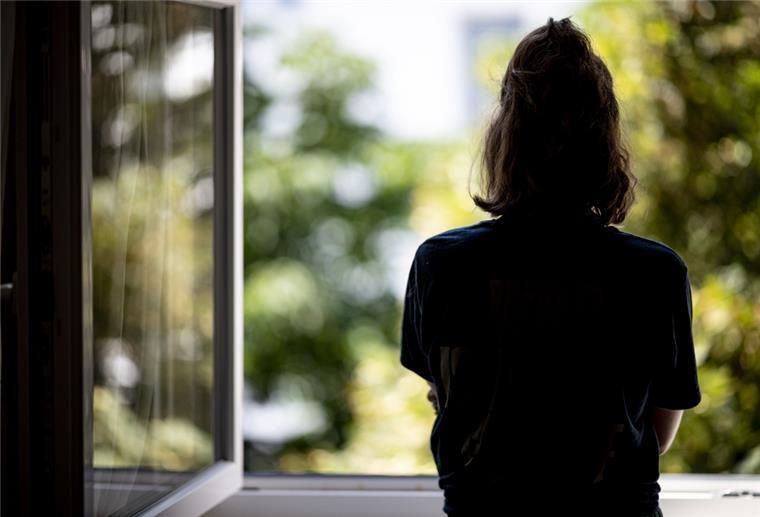 Bremen: Diakonie-Präsident will Einsamkeit aus der Tabuzone holen Eine Frau steht in ihrer Wohnung an einem Fenster.