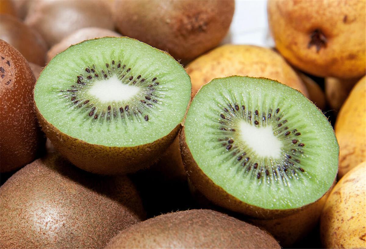 Lecker und gesund: Diese Obstsorten enthalten am wenigsten Zucker Kiwis und Granatäpfel liegen zusammen auf einem Tisch.