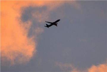 Eine Boeing 737 zeichnet sich vor dem vom Sonnenaufgang verfärbten Morgenhimmel ab.