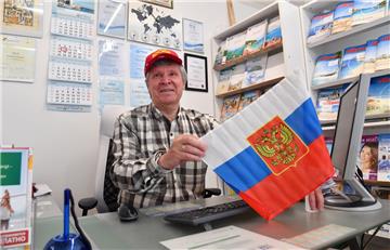 Viktor Wil in seinem Reisebüro. Fürs Foto hat er mal die russische Fanausrüstung getestet. Foto Scheschonka