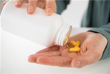 Eine Person schüttet sich Vitamin-Präparate in die Hand: Viel hilft viel? Geht es um Vitamin-Präparate, ist das ein Irrglaube.
