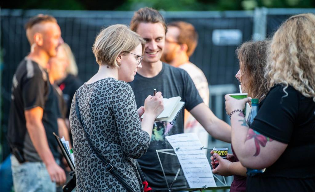 Volontärin Katja Gallas im Gespräch mit Musikern im Backstage-Bereich. Foto: Har...