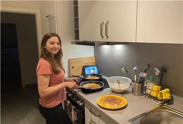 Frau steht in der Küche und kocht.