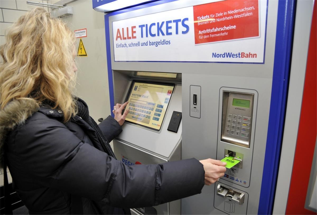 Viele VBN-Fahrgäste dürfen im Oktober zweite Person mitnehmen Eine blonde, junge Frau in einer dicken, schwarzen Jacke steckt ihre grüne BOB-Fahrkarte in einen Fahrkartenautomaten der Nordwestbahn und bedient das Display.