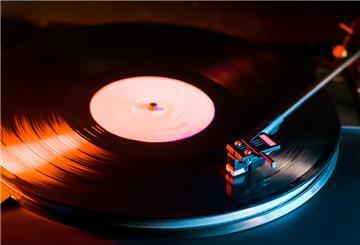 Phono or capsule head of reading an LP turntable spinning. Close up of turntable vinyl stylus going down. Playing the beginning record on player.