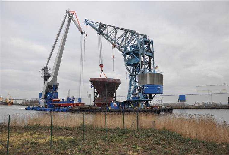 Von Bremen über die Weser und durch den Fischereihafen bringt dieser Verbund aus zwei Schwimmkränen eine Bugsektion für eine ägyptische Fregatte zur Lunehalle. 