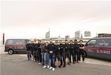 Mitarbeiter Firma Watt & Volt Bremerhaven vor Skyline
