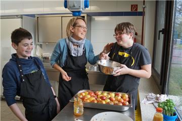 Von links: Oliver Swist (13), Lehrerin Petra Heinemann und Pierre Golumbeck (11) haben viel Spaß beim Vorbereiten von gefüllten Bratäpfel. 