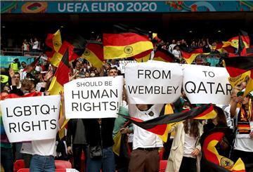 Deutsche Fans halten Plakate mit der Aufschrift "LGBTQ+ RIGHTS" , "SHOULD BE HUMAN RIGHTS!" , "FROM WEMBLEY" , "TO QATAR"  hoch.