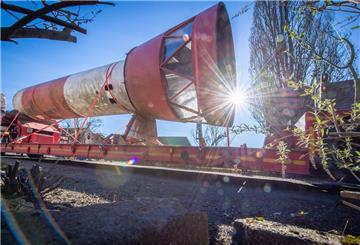 Ein rot-weißer Leuchtturm wird liegend transportiert.