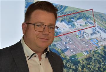 Vor einer Luftbild-Projektion des Kraftwerksgeländes mit dem rot markierten Bereich der Zwischenlager: stellvertretender Zwischenlager-Leiter Stephan Thode.