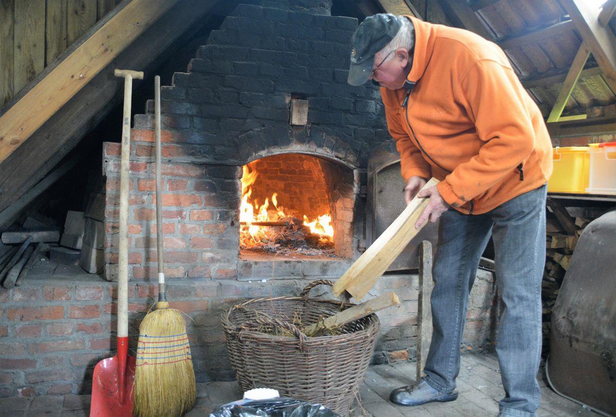 Vorheizen muss sein, um den Winter aus dem Steinbackofen zu vertreiben. Das Feuer knistert munter, und Gerhard Lohse legt noch einige Hölzer nach.