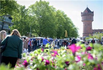 Blütenfestbesucher und Blumen auf dem Konrad-Adenauer-Platz in Bremerhaven-Geestemünde in Sichtweite des Geestemünder Wasserturms.