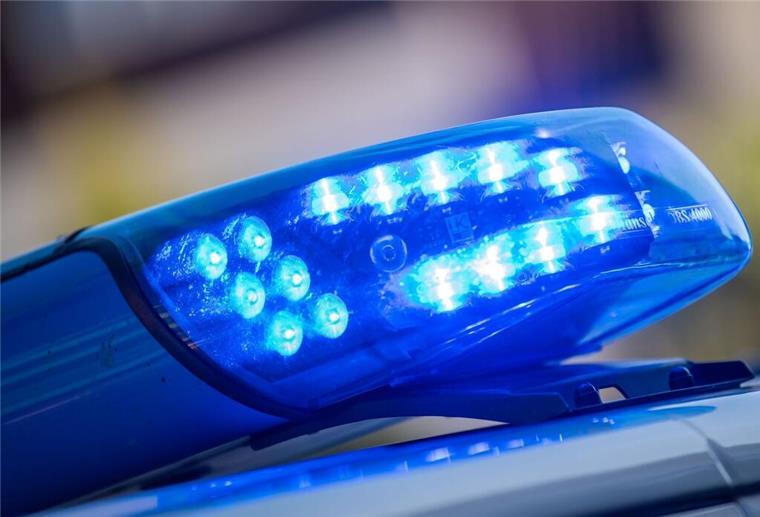 Ein Blaulicht leuchtet unter der Frontscheibe eines Einsatzfahrzeugs der Polizei.