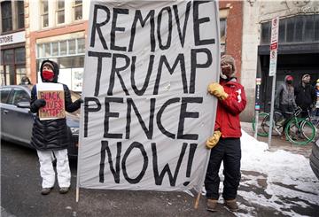Während einer "Black Lives Matter"-Demonstration halten vor einem Polizeirevier zwei Personen ein Banner in den Händen, auf dem die Absetzung von Präsident Donald Trump und Vizepräsident Mike Pence gefordert wird.