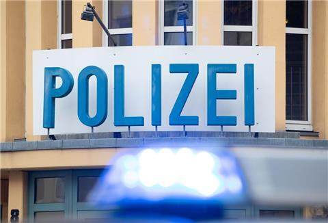 Ein Einsatzwagen der Polizei steht vor einer Dienststelle.