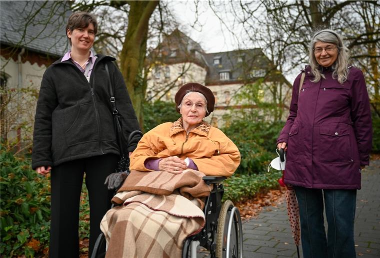 Waltraud Kosak (Mitte) ist mit ihrem Porträt und dem ihres verstorbenen Mannes Erich Teil der Fassade des neuen Traktes des Auswandererhauses. Heute freut sich die 94-Jährige, wenn Tochter Carola (rechts) und Enkelin Bettina sie im Lotte-Lemke-Haus besuchen kommen und eine kleine Runde durch den Park mit ihr drehen. Das Bild entstand vor dem Corona-Lockdown. Foto Scheschonka
